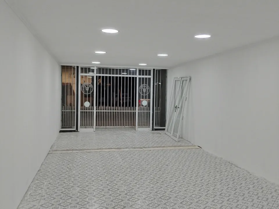 Interior de local terminado con piso cerámico e iluminación instalada