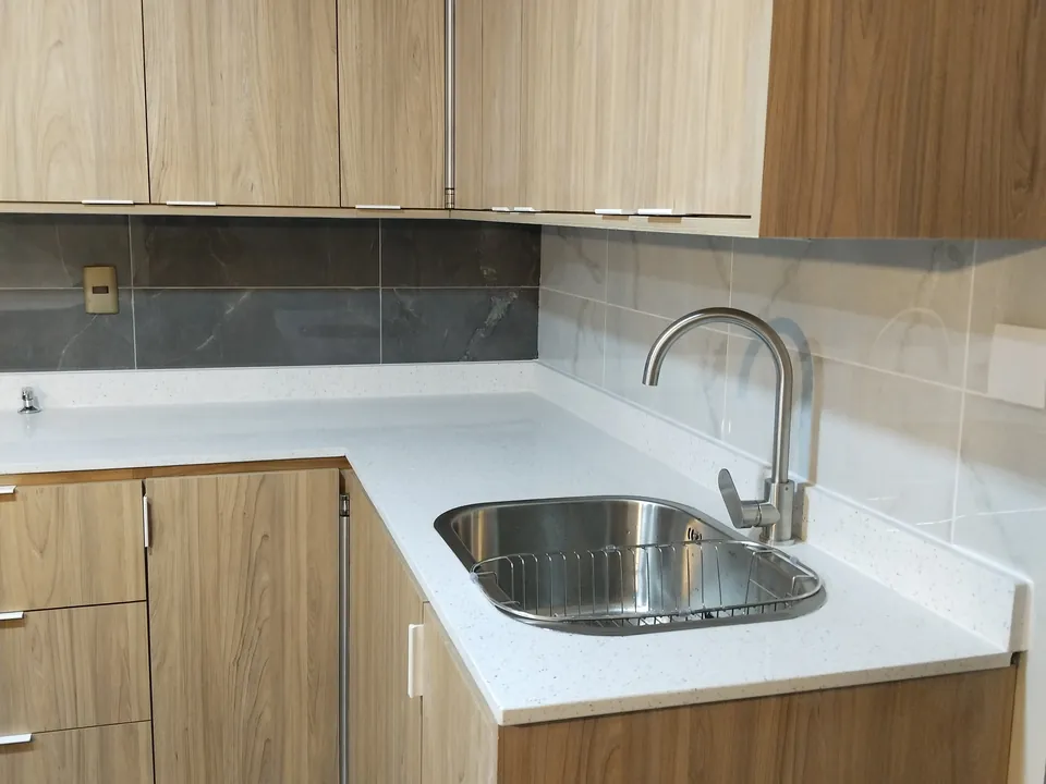 Cocina a medida terminada, encimera y muebles de madera clara